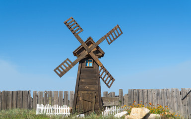 the small wooden windmill against the sky