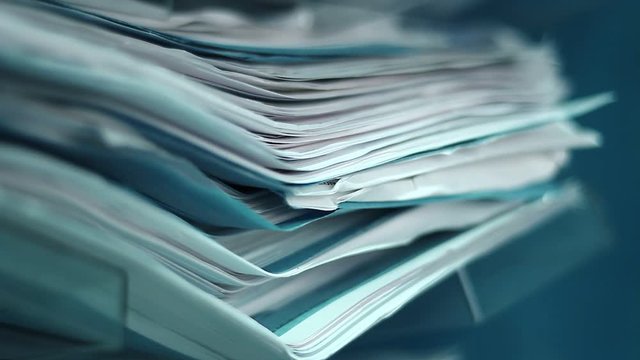 Stack of papers on a shelf. Close up.