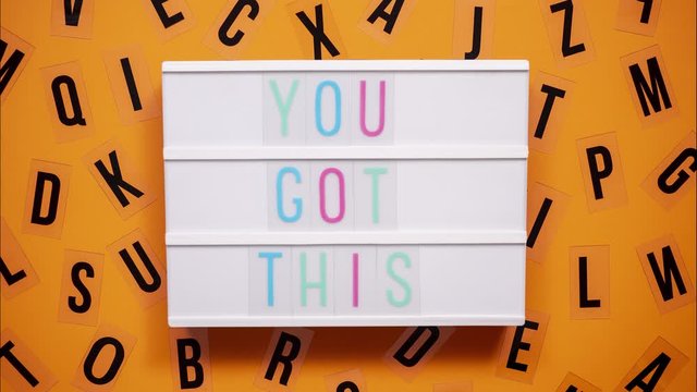 YOU GOT THIS sign on a letter board with letters being animated around. Orange background.
