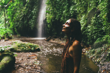 Fototapeta premium Portrait of a girl with war paint. Woman and nature.
