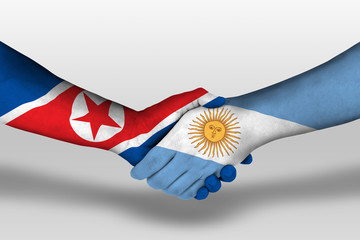 Handshake between argentina and north korea flags painted on hands, illustration with clipping path.