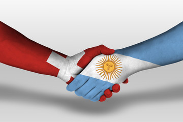 Handshake between argentina and switzerland flags painted on hands, illustration with clipping path.