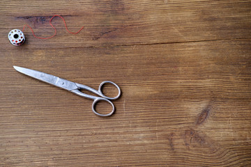 old iron scissors lie on a vintage wooden table, the concept of harmony of two parts, a symbol of life and death, hairdressing, cutting and sewing