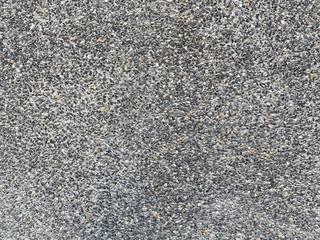Close up Abstract Wall round many small stones building materials gravel surface with grey concrete texture background..