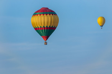 Two bright balloons in flight against a background of blue sky. Colorful balloons of watercolor painting float at different distances.