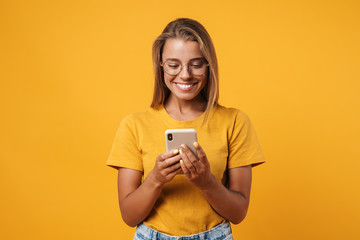Image of cute smiling woman in eyeglasses using cellphone