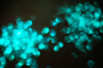 Defocused lights colorful bokeh on black background for celebration design. Abstract blurry backdrop for your design. Modern bright holiday background.