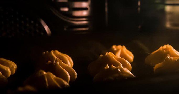 Warm fresh eclair in a bakery. Making bakery and eco production. Manufacturing process working hard. Bakery shop and selling sweets. Baking sweet tender eclairs in oven. Time lapse footage of cooking.