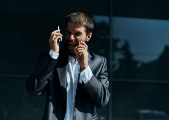 Business man communicates on the phone outdoors emotions executive manager lifestyle