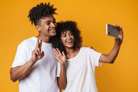 Image of african american couple taking selfie on smartphones