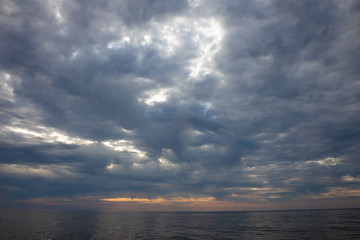 Seascape. Waves and surf. Sunset and dawn at sea. Calm on the ocean. Beautiful sky and clouds illuminated by the sun. Natural background. Summer time.