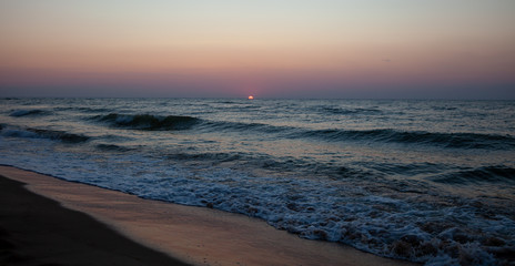 Seascape. Waves and surf. Sunset and dawn at sea. Calm on the ocean. Beautiful sky and clouds illuminated by the sun. Natural background. Summer time.