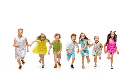 Happy children, little and emotional caucasian kids jumping and running isolated on white background. Looks happy, cheerful, sincere. Copyspace for ad. Childhood, education, happiness concept.