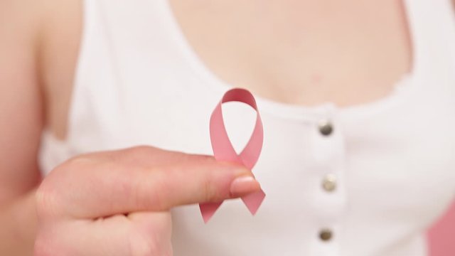 Close Up, Woman Holding Symbolic Pink Ribbon, Brest Cancer Awareness Concept. High Quality 4k Footage