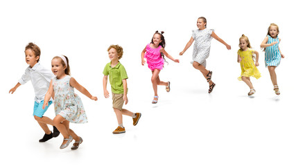 Fototapeta premium Happy children, little and emotional caucasian kids jumping and running isolated on white background. Looks happy, cheerful, sincere. Copyspace for ad. Childhood, education, happiness concept.