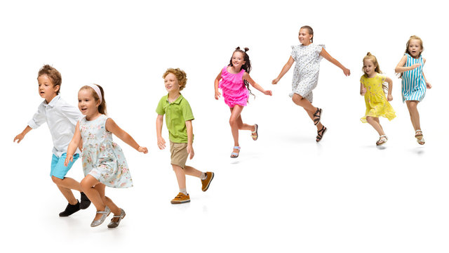 Happy children, little and emotional caucasian kids jumping and running isolated on white background. Looks happy, cheerful, sincere. Copyspace for ad. Childhood, education, happiness concept.
