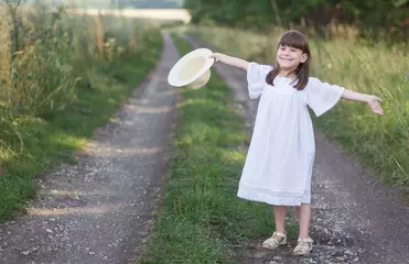 Foto op Canvas Mooi meisje met een hoed staat op een weg in de buurt van roggeveld. © Albert Ziganshin