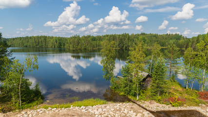 A scenic secluded place on the shore of a northern forest lake on a sunny summer day	