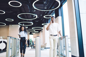 Coworkers passing through contemporary access control at workplace