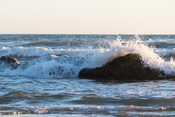 ola chocando contra la roca