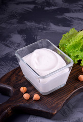Vegan chickpea mayonnaise made of aquafaba in a glass bowl on the wooden board