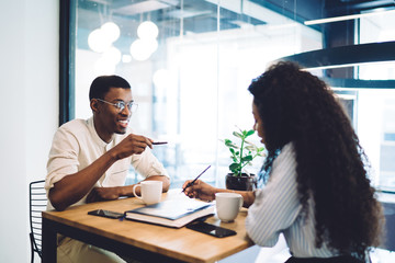 Smiling black couple speaking in cafe