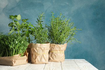 Different herbs on white wooden table against blue background