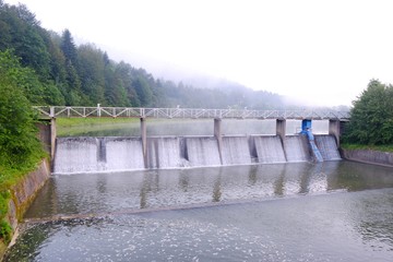 Dam on Krempna reservoir on magical misty morning. Low Beskids Mountains, Poland