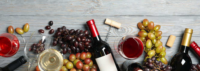 Composition with wine and grape on wooden background, space for text