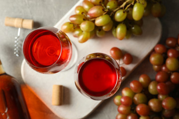 Composition with wine and grape on gray background, top view