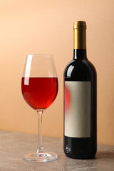Bottle and glass of wine on gray table, space for text
