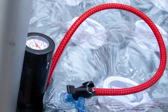 Pump with red hose for inflating different products.