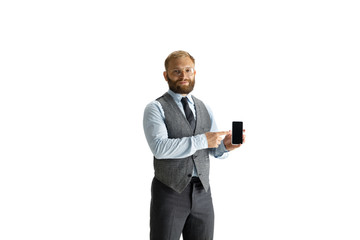 Cheerful handsome businessman isolated over white studio background, copyspace. Modern young director, manager in office suit, full length portrait. Using devices, gadgets. Business, finance, tech