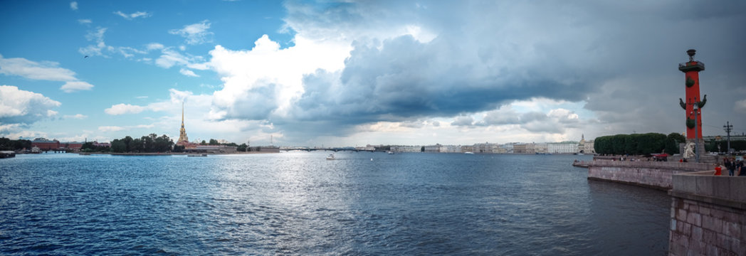 Panoramic summer shot of St. Petersburg, Russia. View of the Neva River with boats, Peter and Paul Fortress, Spit of Vasilyevsky Island, Rastral Columns, Troitsky Bridge. City architecture, museums