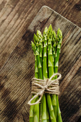 Bunch of fresh green asparagus on wood board. Close up