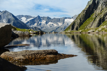 Naklejka na ściany i meble Bergsee mit Spiegelung eines Gebirges im Hintergrund in Tirol Österreich