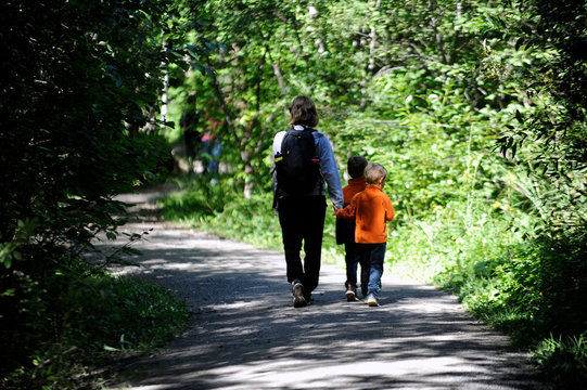 une m&egrave;re et ses enfants marchant dans la for&ecirc;t