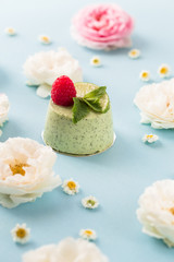 Fototapeta na wymiar Pistachio mousse cake, cheesecake with fresh raspberry on white plate with mint leaves