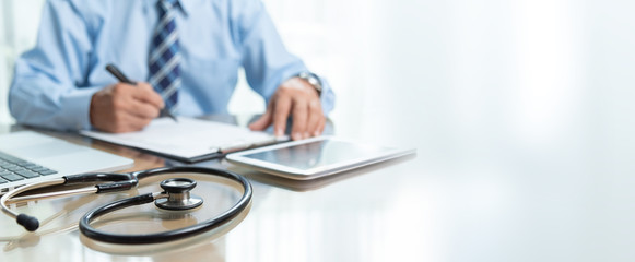 Focus on Stethoscope, Doctor writing on prescription, banner