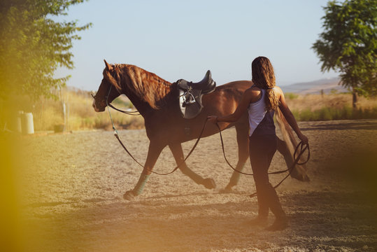 Chica dando cuerda a su caballo al atardecer en Andalucia 