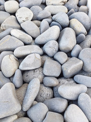 Background of gray sea stones of different shapes and tones. Small Naturally Polished Rocks, Pebbles background and pattern.