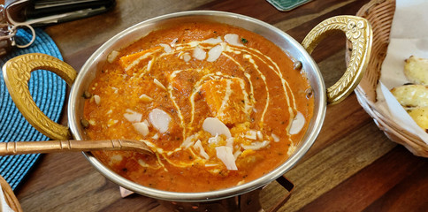 Indian food including curries, spice sauce and naan bread.