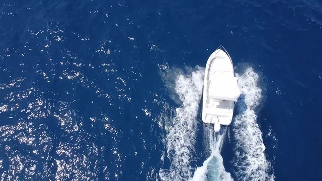 White Speed Boat Sailing Across The Blue Water Of Castellammare Gulf Near The Scopello, Trapani In Sicily, Italy.  - aerial drone