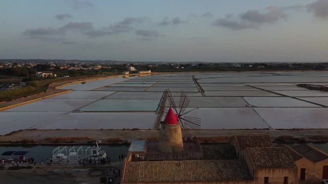 Aerial View Of The Famous Windmill In The Salt Pans In Mazara Del Vallo, Sicily, Italy On A Sunset - panning drone shot