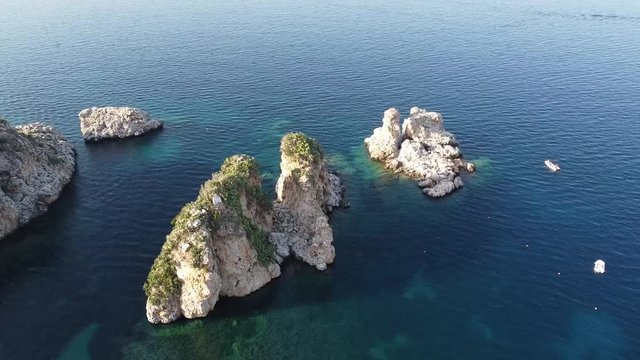 Faraglioni, Stacks Of Scopello By The Calm Water Of Castellammare Del Golfo In Trapani, Sicily, Italy.  - aerial drone shot