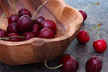 Cherries in a wooden bowl. Cherries in a bowl. Ripe cherries on the table
