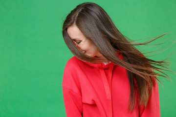 Smiling cheerful pretty young brunette woman 20s in red casual streetwear hoodie eyeglasses posing...