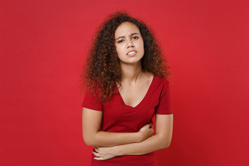 Sick young african american woman girl in casual t-shirt isolated on red background studio...