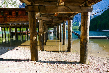 Fototapeta na wymiar under the wooden pier of an alpine lake