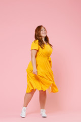 Full length portrait of cheerful beautiful charming young redhead plus size body positive female...